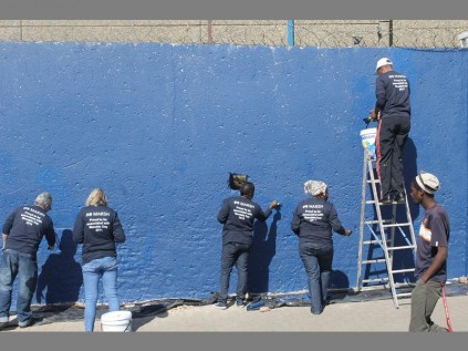 Despite the height, Marsh staff members and Alex High staff, pupils and school governing body members complete painting the school wall on Mandela Day.