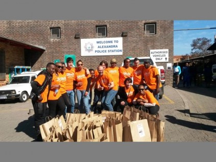 Zinto’s team of performers hand out food parcels to officers at the Alexandra Police Station.