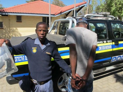 A SANDRINGHAM detective with one of the two suspects arrested in 15th Avenue, Alexandra, shows-off the toy guns allegedly found in their possession.