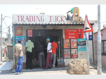A foreign owned shop which was broken into in Alex last night. A contractor can be seen on top repairing the damage.