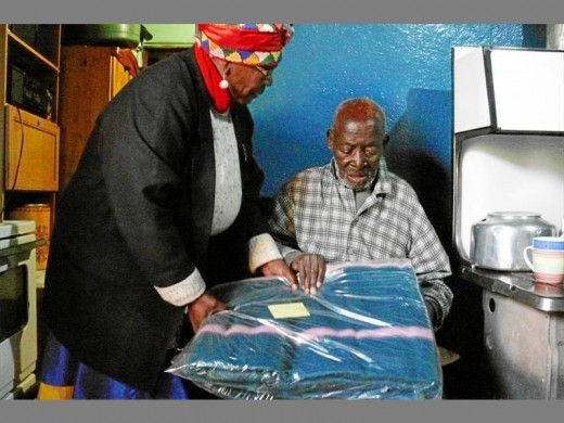THUSONG Youth Centre founder, Beauty More, hands Johannes Mdelwa Nkosi some birthday presents in a previous celebration.