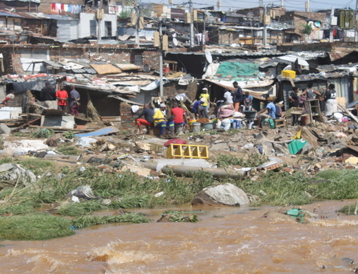 Setswetla Informal Settlement dwellers retrieve what little they can after the Jukskei River floods.