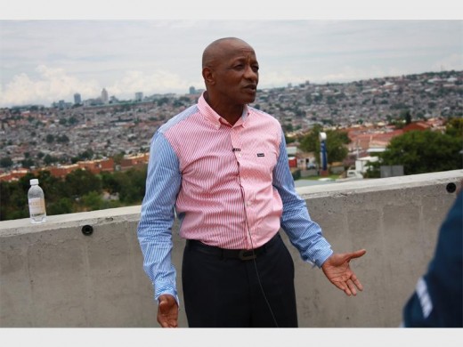 Galxcoc president Mpho Motsumi stands against the backdrop of Alexandra and the continent's richest square mile, Sandton.