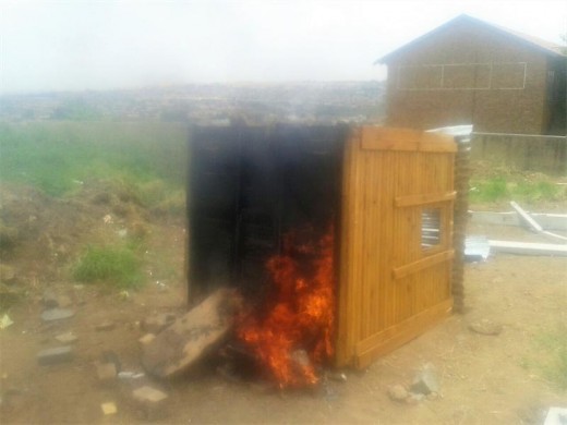 A security house, behind an informal settlement, that was allegedly set alight by people who had been forced to leave.